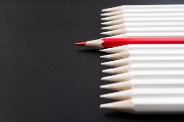 İş ve tasarım konsepti - beyaz kalem ve siyah arka plan üzerinde bir renk kalem çok. Liderlik, takım çalışması, başarı ve benzersiz sembolü.