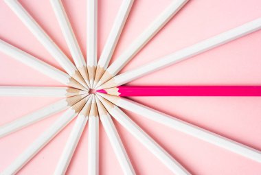 İş ve tasarım konsepti - beyaz kalem ve pembe kağıt arka plan üzerinde bir renk kalem çok. Liderlik, takım çalışması, başarı ve benzersiz sembolü.