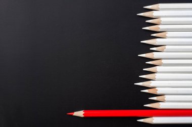 İş ve tasarım konsepti - beyaz kalem ve siyah arka plan üzerinde bir renk kalem çok. Liderlik, takım çalışması, başarı ve benzersiz sembolü.