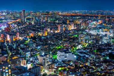 Gayrimenkul ve kurumsal inşaat için Asya İş kavramı - Tokyo, Japonya'da alacakaranlık gökyüzü ve neon gece altında panoramik kentsel şehir silueti hava görünümü.