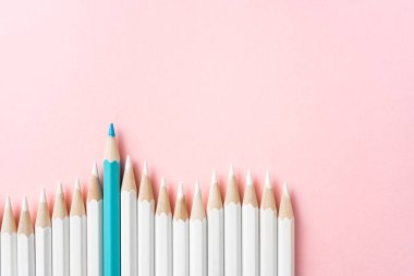 İş ve tasarım konsepti - beyaz kalem ve pembe kağıt arka plan üzerinde bir renk kalem çok. Liderlik, takım çalışması, başarı ve benzersiz sembolü.