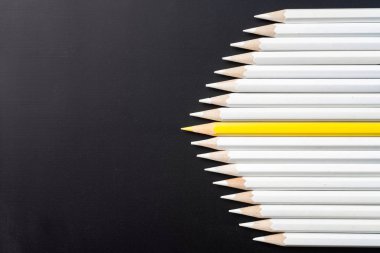 İş ve tasarım konsepti - beyaz kalem ve siyah arka plan üzerinde bir renk kalem çok. Liderlik, takım çalışması, başarı ve benzersiz sembolü.