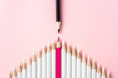 İş ve tasarım konsepti - pembe kağıt arka plan üzerinde beyaz kalemler ve renkli kalemler çok. Liderlik, takım çalışması, başarı ve benzersiz sembolü.