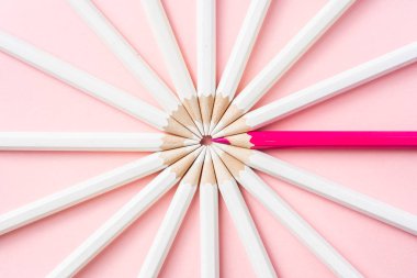 İş ve tasarım konsepti - beyaz kalem ve pembe kağıt arka plan üzerinde bir renk kalem çok. Liderlik, takım çalışması, başarı ve benzersiz sembolü.