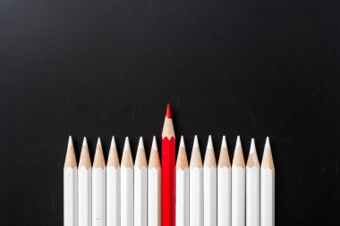 İş ve tasarım konsepti - beyaz kalem ve siyah arka plan üzerinde bir renk kalem çok. Liderlik, takım çalışması, başarı ve benzersiz sembolü.