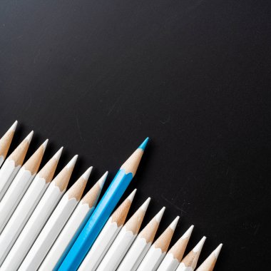 İş ve tasarım konsepti - beyaz kalem ve siyah arka plan üzerinde bir renk kalem çok. Liderlik, takım çalışması, başarı ve benzersiz sembolü.
