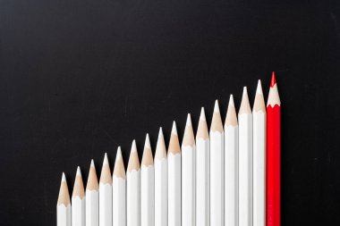 İş ve tasarım konsepti - beyaz kalem ve siyah arka plan üzerinde bir renk kalem çok. Liderlik, takım çalışması, başarı ve benzersiz sembolü.