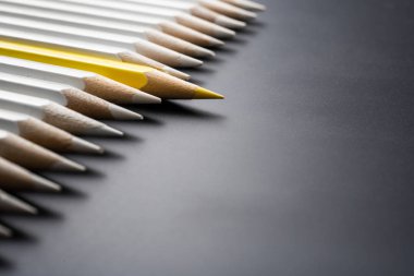 İş ve tasarım konsepti - beyaz kalem ve siyah arka plan üzerinde bir renk kalem çok. Liderlik, takım çalışması, başarı ve benzersiz sembolü.