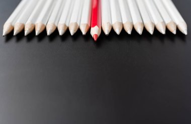 İş ve tasarım konsepti - beyaz kalem ve siyah arka plan üzerinde bir renk kalem çok. Liderlik, takım çalışması, başarı ve benzersiz sembolü.