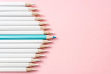 İş ve tasarım konsepti - beyaz kalem ve pembe kağıt arka plan üzerinde bir renk kalem çok. Liderlik, takım çalışması, başarı ve benzersiz sembolü.