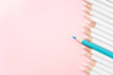 İş ve tasarım konsepti - beyaz kalem ve pembe kağıt arka plan üzerinde bir renk kalem çok. Liderlik, takım çalışması, başarı ve benzersiz sembolü.