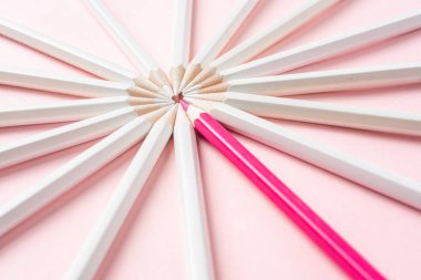 İş ve tasarım konsepti - beyaz kalem ve pembe kağıt arka plan üzerinde bir renk kalem çok. Liderlik, takım çalışması, başarı ve benzersiz sembolü.