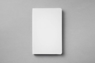 Mockup için gri arka plan üzerinde beyaz not defteriüst görünümü.