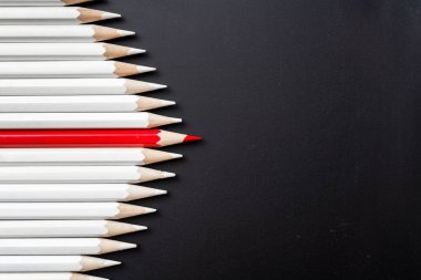 İş ve tasarım konsepti - beyaz kalem ve siyah arka plan üzerinde bir renk kalem çok. Liderlik, takım çalışması, başarı ve benzersiz sembolü.