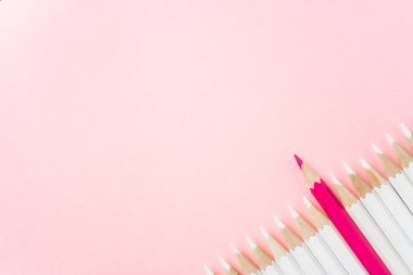 İş ve tasarım konsepti - beyaz kalem ve pembe kağıt arka plan üzerinde bir renk kalem çok. Liderlik, takım çalışması, başarı ve benzersiz sembolü.