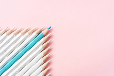 İş ve tasarım konsepti - beyaz kalem ve pembe kağıt arka plan üzerinde bir renk kalem çok. Liderlik, takım çalışması, başarı ve benzersiz sembolü.
