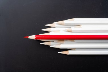 İş ve tasarım konsepti - beyaz kalem ve siyah arka plan üzerinde bir renk kalem çok. Liderlik, takım çalışması, başarı ve benzersiz sembolü.