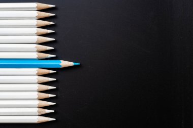 İş ve tasarım konsepti - beyaz kalem ve siyah arka plan üzerinde bir renk kalem çok. Liderlik, takım çalışması, başarı ve benzersiz sembolü.