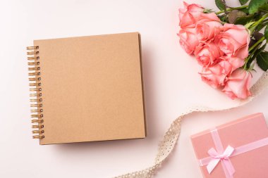 Pembe gül buketi, hediye kutusu, dizüstü bilgisayar ve pembe arka plan üzerinde vintage kurdele