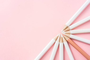 İş ve tasarım konsepti - beyaz kalem ve pembe kağıt arka plan üzerinde bir renk kalem çok. Liderlik, takım çalışması, başarı ve benzersiz sembolü.