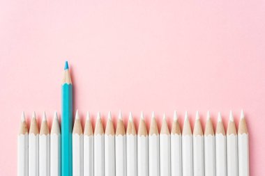 İş ve tasarım konsepti - beyaz kalem ve pembe kağıt arka plan üzerinde bir renk kalem çok. Liderlik, takım çalışması, başarı ve benzersiz sembolü.