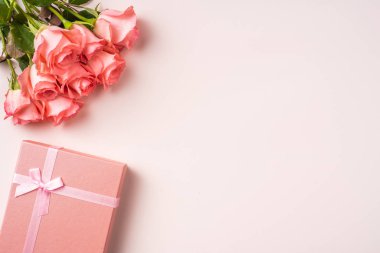 Pembe gül buketi, pembe arka plan üzerinde hediye kutusu