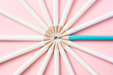 İş ve tasarım konsepti - beyaz kalem ve pembe kağıt arka plan üzerinde bir renk kalem çok. Liderlik, takım çalışması, başarı ve benzersiz sembolü.