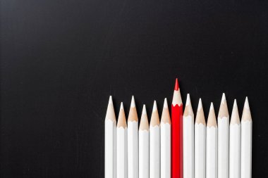 İş ve tasarım konsepti - beyaz kalem ve siyah arka plan üzerinde bir renk kalem çok. Liderlik, takım çalışması, başarı ve benzersiz sembolü.