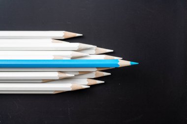 İş ve tasarım konsepti - beyaz kalem ve siyah arka plan üzerinde bir renk kalem çok. Liderlik, takım çalışması, başarı ve benzersiz sembolü.