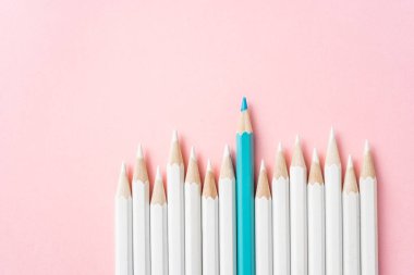 İş ve tasarım konsepti - beyaz kalem ve pembe kağıt arka plan üzerinde bir renk kalem çok. Liderlik, takım çalışması, başarı ve benzersiz sembolü.