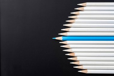 İş ve tasarım konsepti - beyaz kalem ve siyah arka plan üzerinde bir renk kalem çok. Liderlik, takım çalışması, başarı ve benzersiz sembolü.