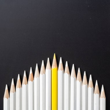 İş ve tasarım konsepti - beyaz kalem ve siyah arka plan üzerinde bir renk kalem çok. Liderlik, takım çalışması, başarı ve benzersiz sembolü.