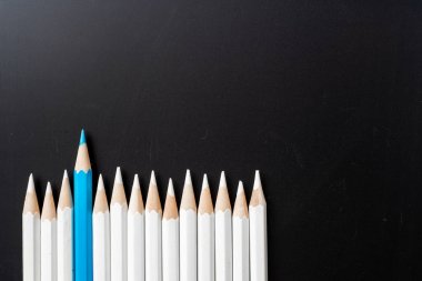 İş ve tasarım konsepti - beyaz kalem ve siyah arka plan üzerinde bir renk kalem çok. Liderlik, takım çalışması, başarı ve benzersiz sembolü.