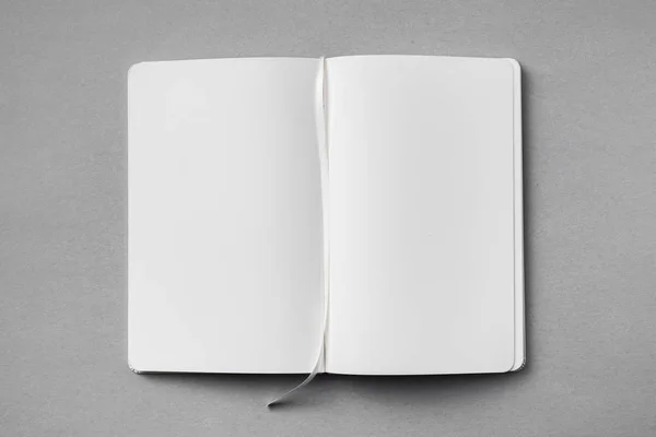 モックアップのための灰色の背景にリボンブックマーク付き開いた白いノートブックのトップビュー — ストック写真
