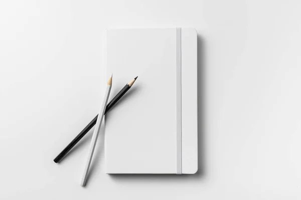 Ελάχιστο Λευκό Σημειωματάριο Ελαστική Μπάντα Και Ξύλινα Μολύβια Απομονωμένα Λευκό — Φωτογραφία Αρχείου