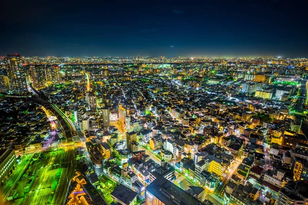 Gayrimenkul ve kurumsal inşaat için Asya İş kavramı - Tokyo, Japonya'da alacakaranlık gökyüzü ve neon gece altında panoramik kentsel şehir silueti hava görünümü.