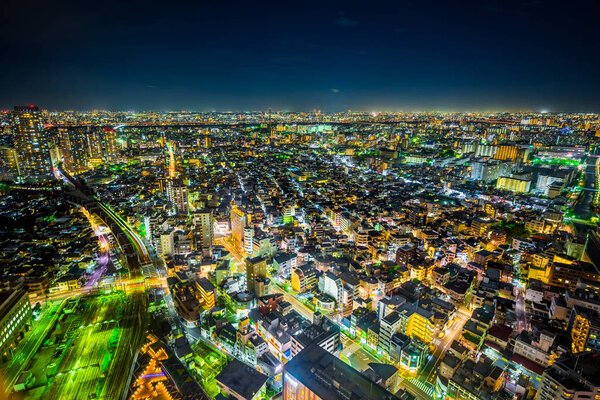 Asian Business concept for real estate and corporate construction - panoramic urban city skyline aerial view under twilight sky and neon night in Tokyo, Japan.