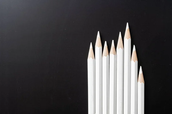 商业和设计理念 黑色背景上的大量白色铅笔 团队合作 成功和独特的象征 — 图库照片