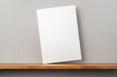A4 sert kağıt kitapçık ve mockup için gri duvar üzerinde duruyor