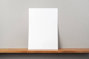 Maket için kitaplık ve gri duvar üzerinde duran A4 kağıt ön görünümü