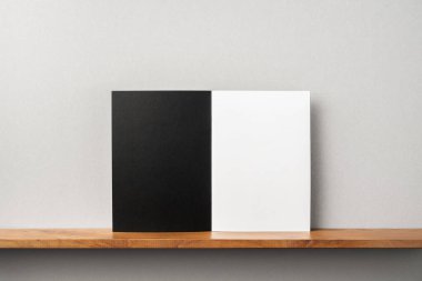 Siyah dergi kitapçık ve mockup için gri duvar üzerinde duran