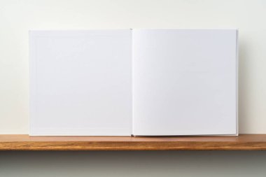 Kitaplık ta kare beyaz defter ve mockup için beyaz duvar