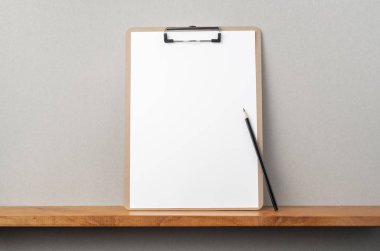 Kitapçık ve gri duvar üzerinde pano ve kalem ile A4 kağıt ön görünümü mockup için