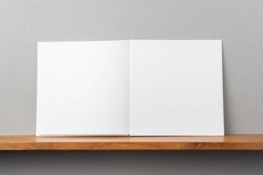 Tasarım konsepti - kitaplık ve mockup için gri duvar açık kare beyaz dizüstü ön görünümü