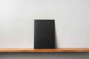 Siyah dergi kitapçık ve mockup için gri duvar üzerinde duran