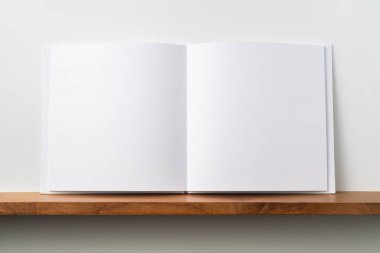 Kitaplık ta kare beyaz defter ve mockup için beyaz duvar