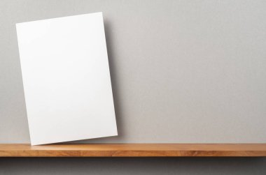 A4 sert kağıt kitapçık ve mockup için gri duvar üzerinde duruyor