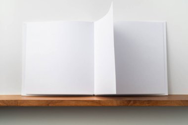 Kitaplık ta kare beyaz defter ve mockup için beyaz duvar