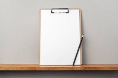 Kitapçık ve gri duvar üzerinde pano ve kalem ile A4 kağıt ön görünümü mockup için