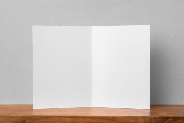 Mockup için kitaplık ve gri duvar da tebrik kartı ön görünümü.